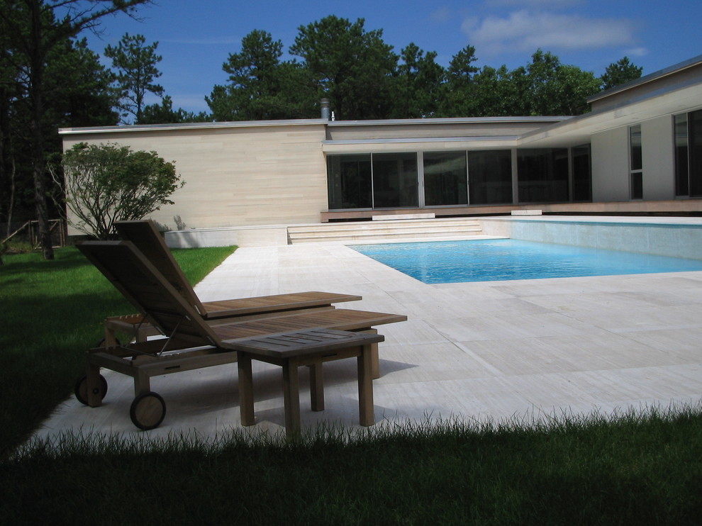 Idéer för en modern pool på baksidan av huset, med kakelplattor