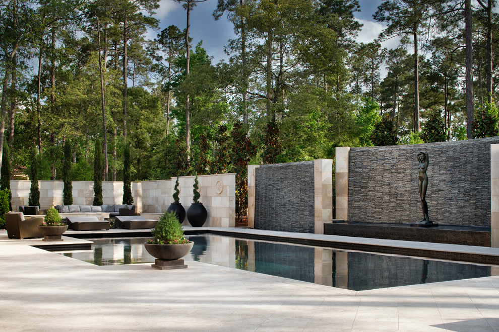 Immagine di una piscina classica dietro casa con fontane