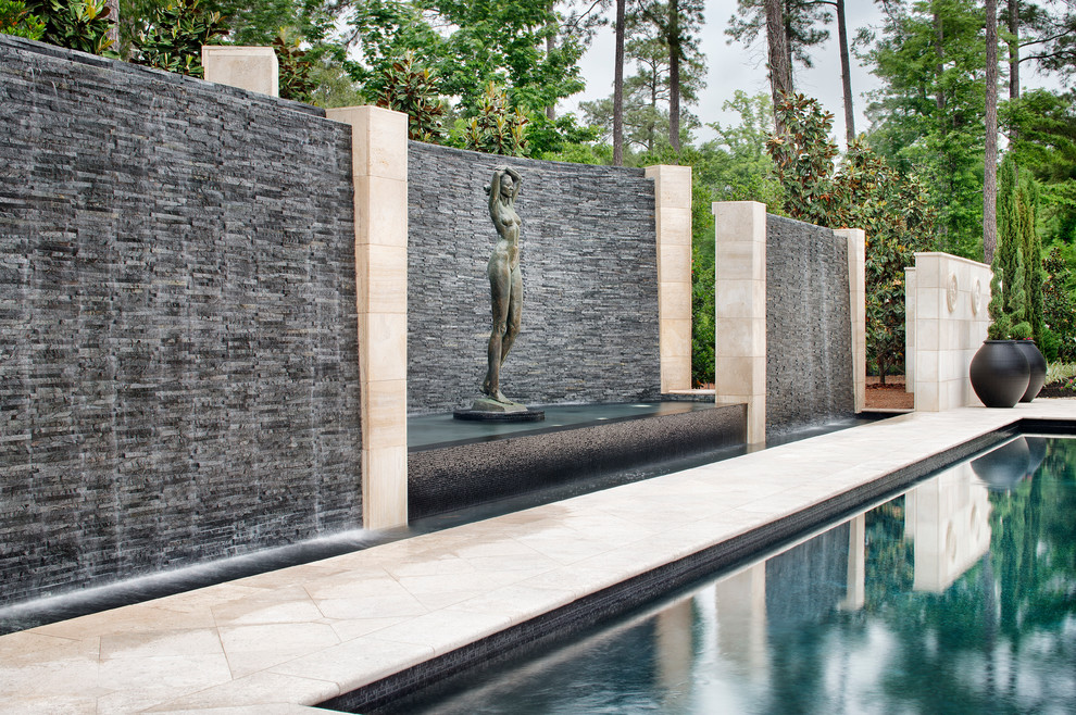 This is an example of an expansive classic back custom shaped swimming pool in Houston with a water feature.