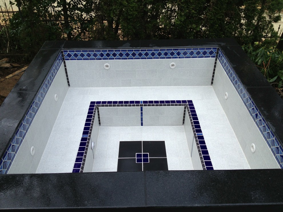 На фото: бассейн среднего размера, произвольной формы на заднем дворе в стиле модернизм с джакузи и покрытием из декоративного бетона