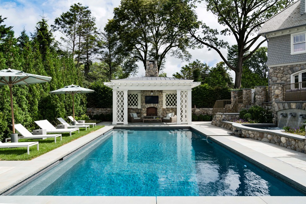 Пример оригинального дизайна: прямоугольный бассейн на заднем дворе в морском стиле с домиком у бассейна и покрытием из бетонных плит