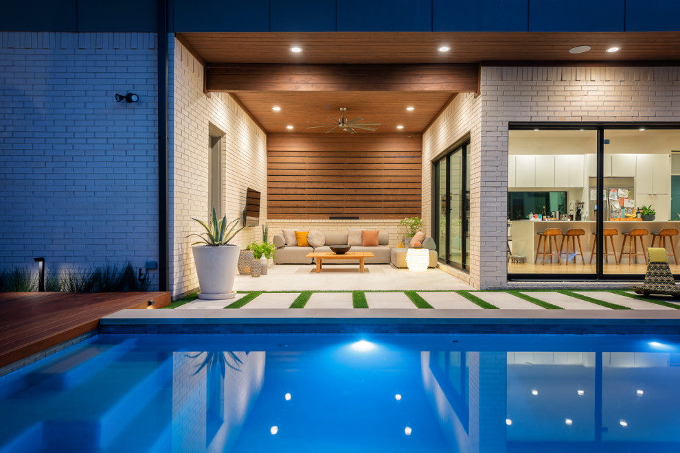 Idéer för att renovera en mellanstor funkis rektangulär pool på baksidan av huset, med naturstensplattor