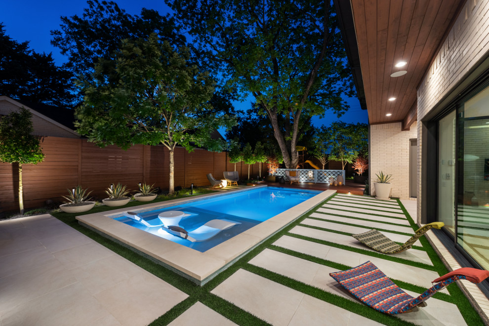 Foto di una piscina minimalista rettangolare di medie dimensioni e dietro casa con pavimentazioni in pietra naturale
