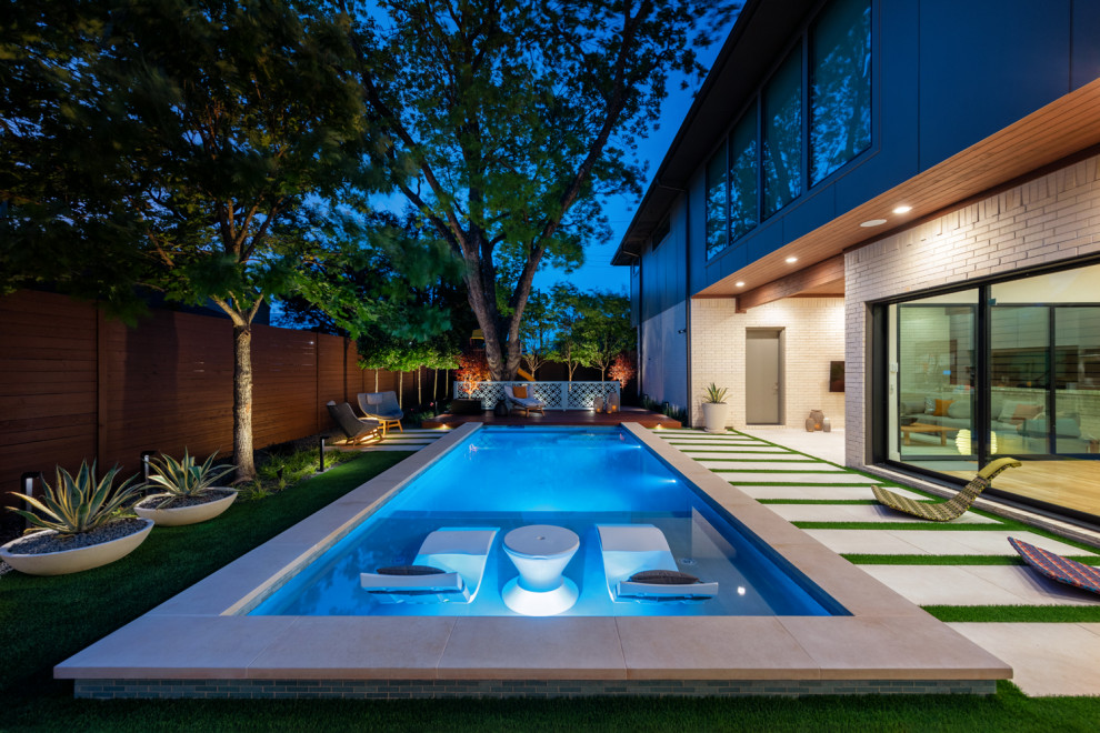 Foto på en mellanstor funkis pool på baksidan av huset, med naturstensplattor