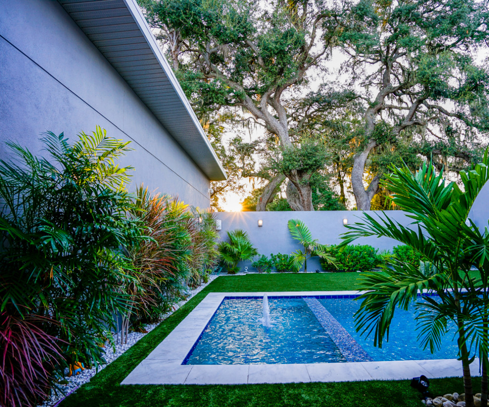 Ispirazione per una piscina design rettangolare di medie dimensioni e in cortile con una vasca idromassaggio