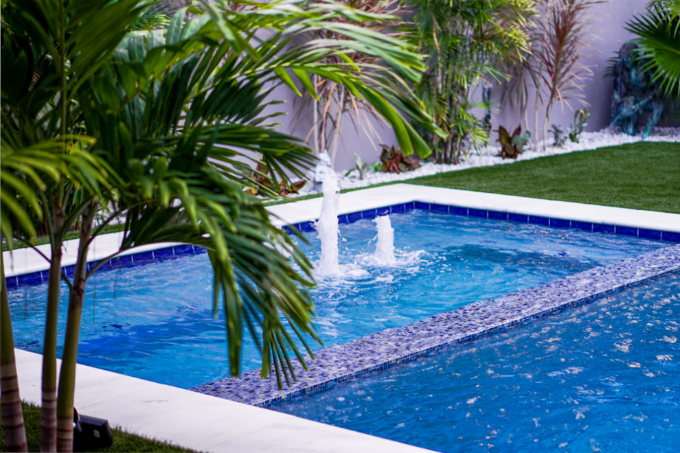 Exemple d'une piscine tendance de taille moyenne et rectangle avec un bain bouillonnant et une cour.