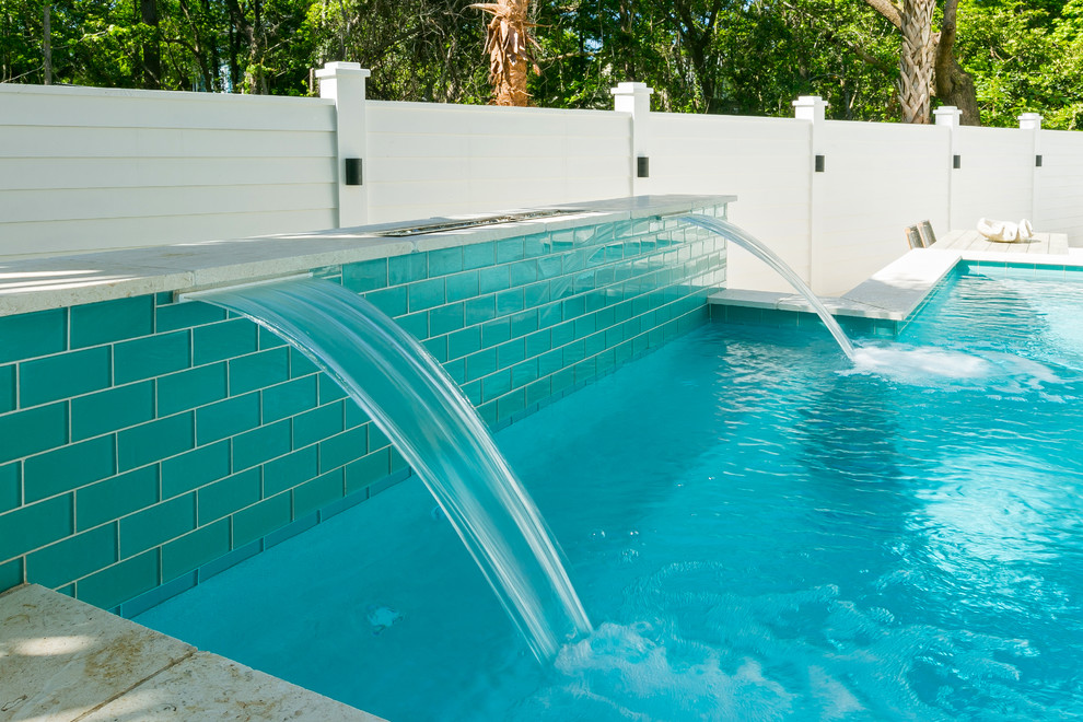 Idée de décoration pour une piscine hors-sol et arrière design de taille moyenne et sur mesure avec un point d'eau et des pavés en pierre naturelle.