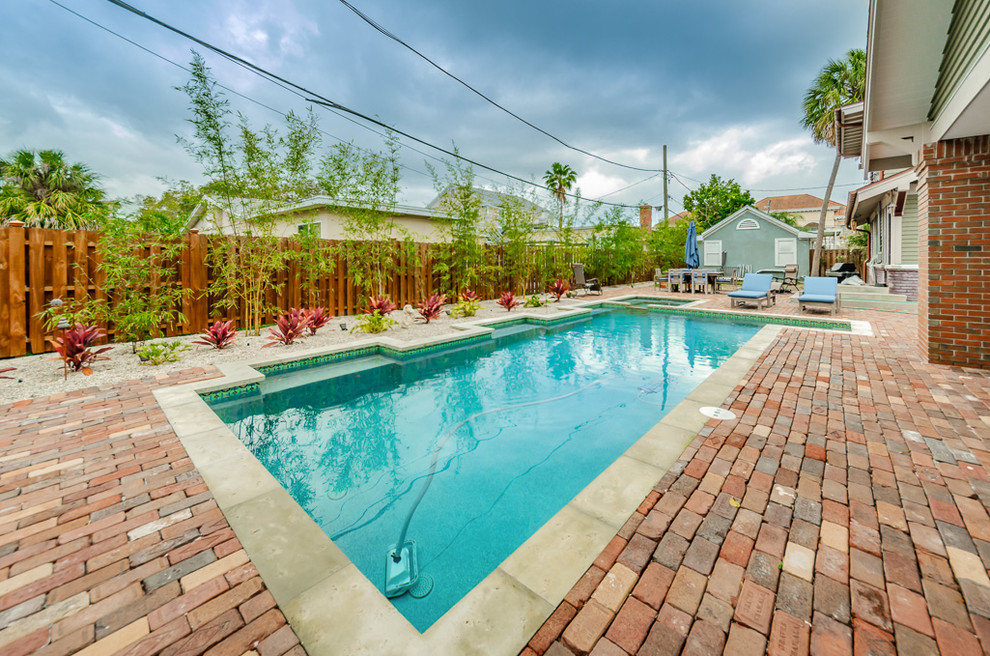 Foto di una piscina naturale stile marino personalizzata di medie dimensioni e dietro casa con una vasca idromassaggio e pavimentazioni in mattoni