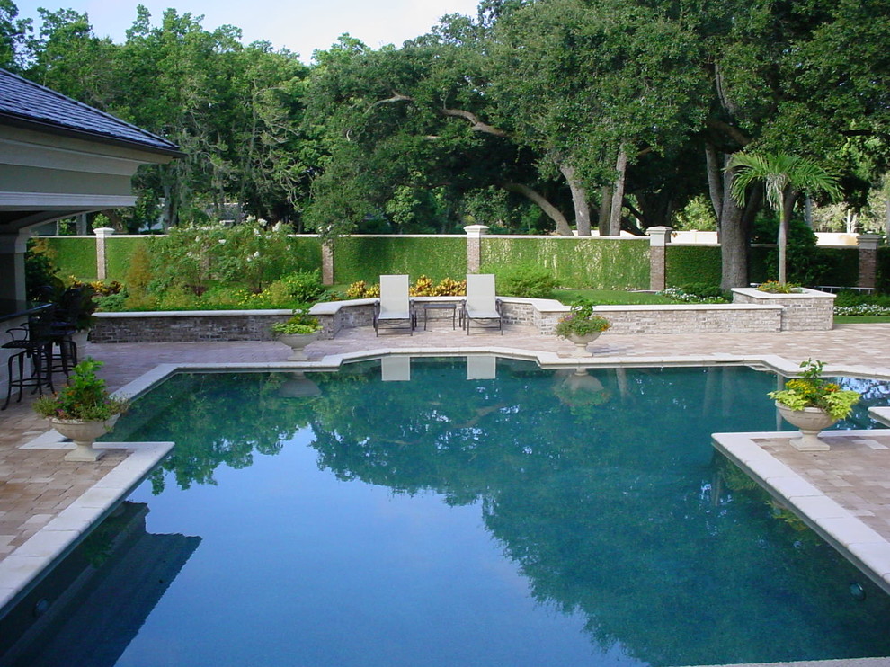 Pool - huge traditional backyard brick and custom-shaped pool idea in Tampa