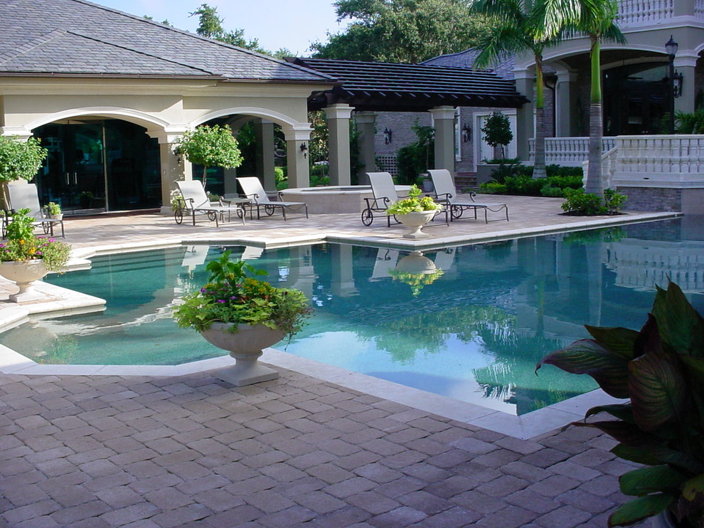 Imagen de casa de la piscina y piscina tradicional grande a medida en patio trasero con adoquines de hormigón