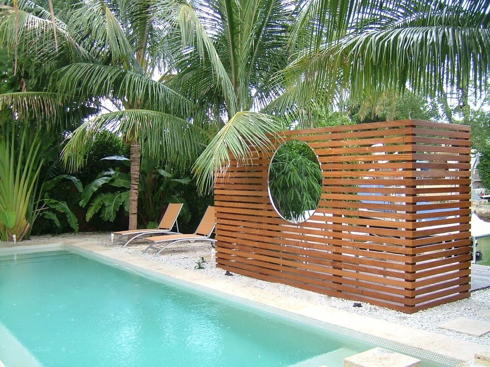 Immagine di una grande piscina monocorsia tropicale rettangolare con piastrelle