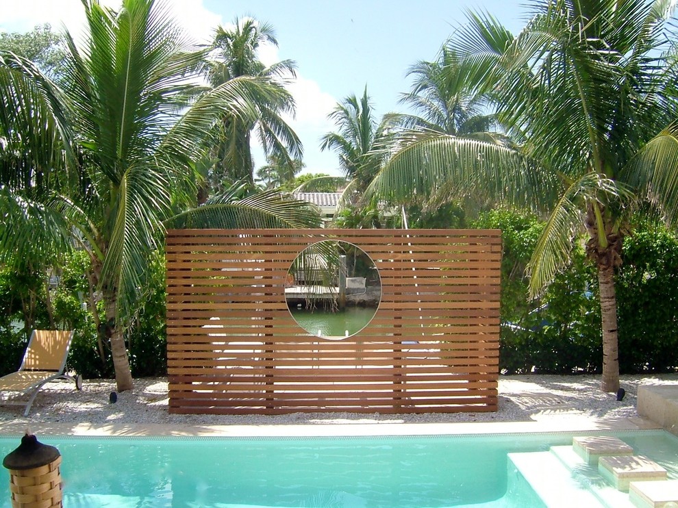 マイアミにある広いトロピカルスタイルのおしゃれな競泳用プール (タイル敷き) の写真
