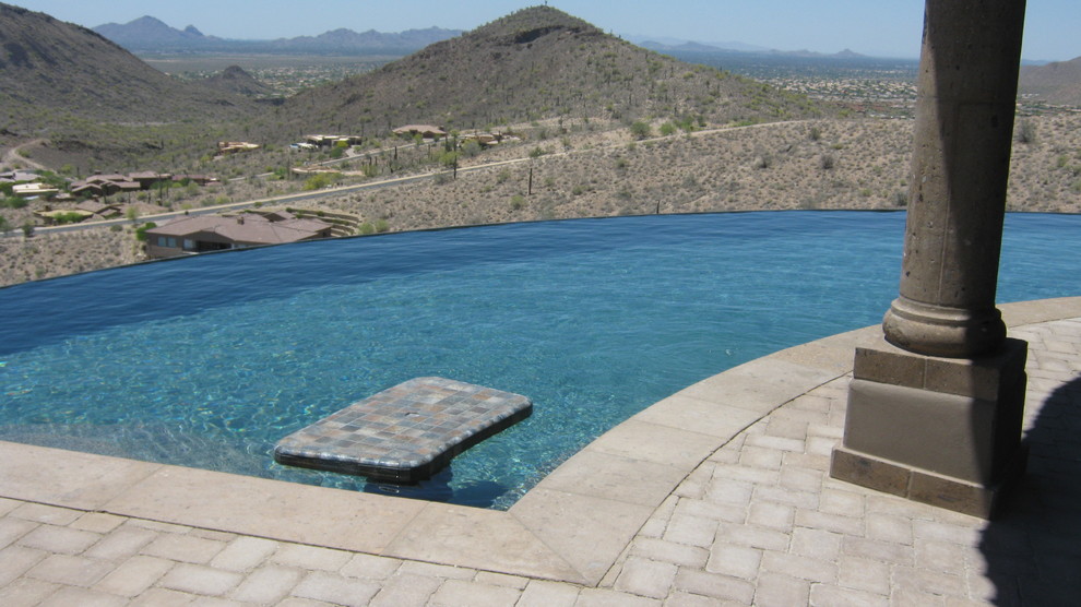 Imagen de piscinas y jacuzzis infinitos minimalistas grandes a medida en patio trasero con adoquines de ladrillo