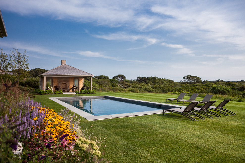 Пример оригинального дизайна: большой прямоугольный бассейн на заднем дворе в морском стиле с домиком у бассейна и мощением тротуарной плиткой