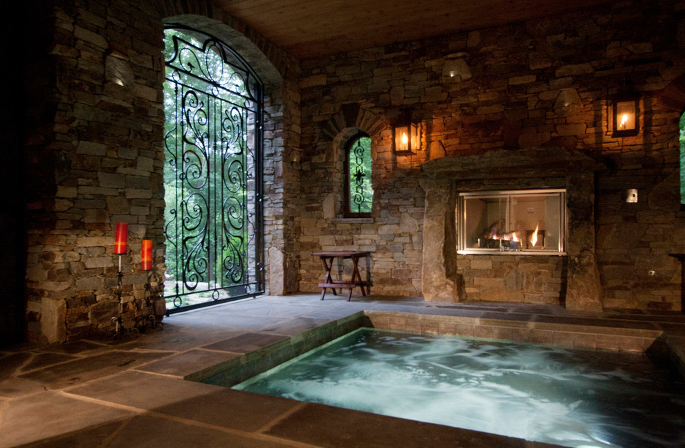 Immagine di una piscina coperta classica con pavimentazioni in pietra naturale