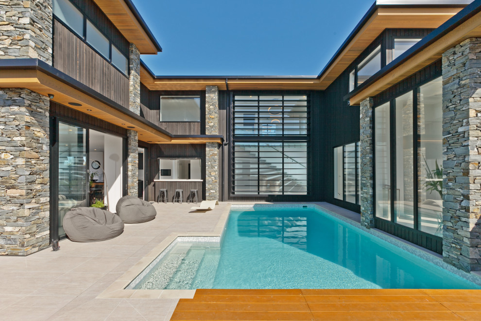 Aménagement d'une très grande piscine arrière contemporaine rectangle avec du carrelage.