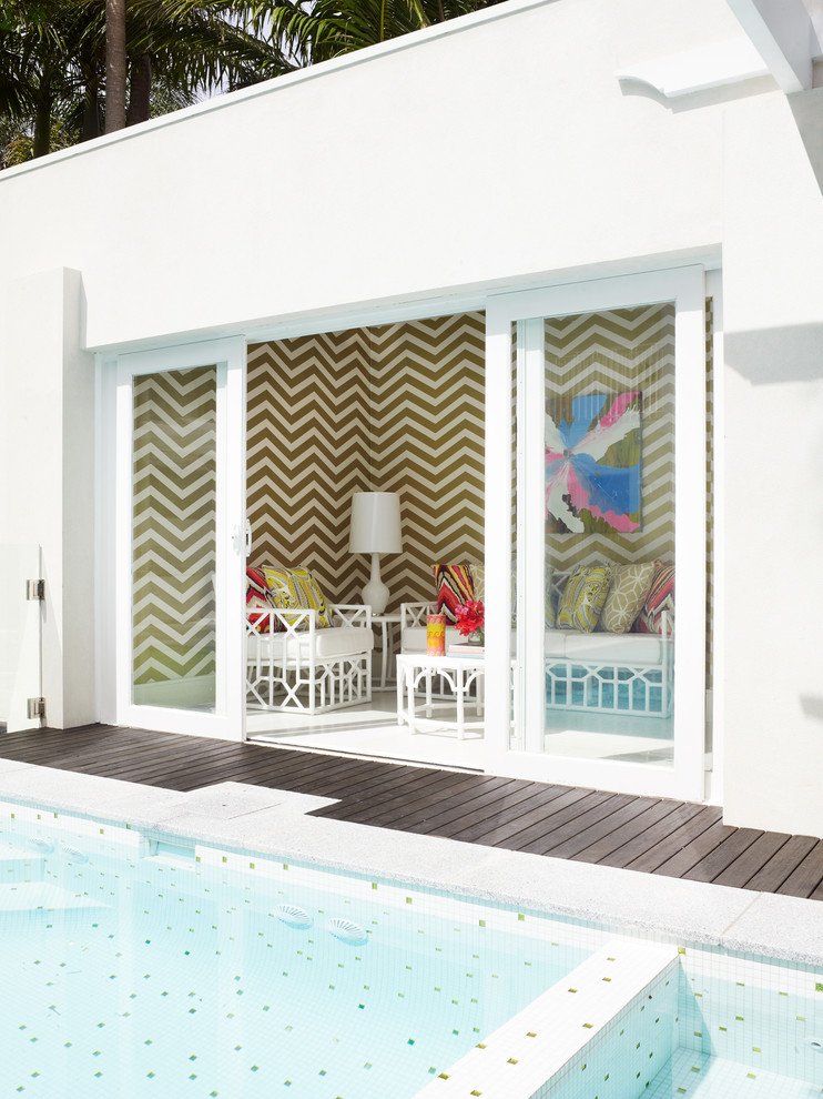 Идея дизайна: большой бассейн произвольной формы на заднем дворе в стиле модернизм с домиком у бассейна и покрытием из плитки