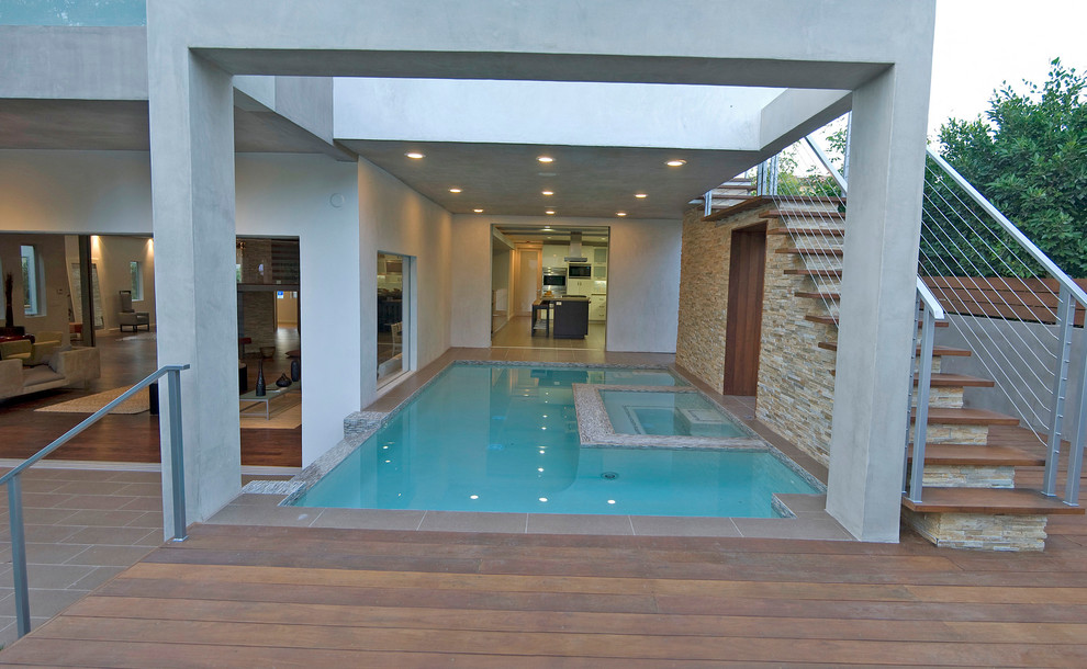 Immagine di una piscina design con una vasca idromassaggio