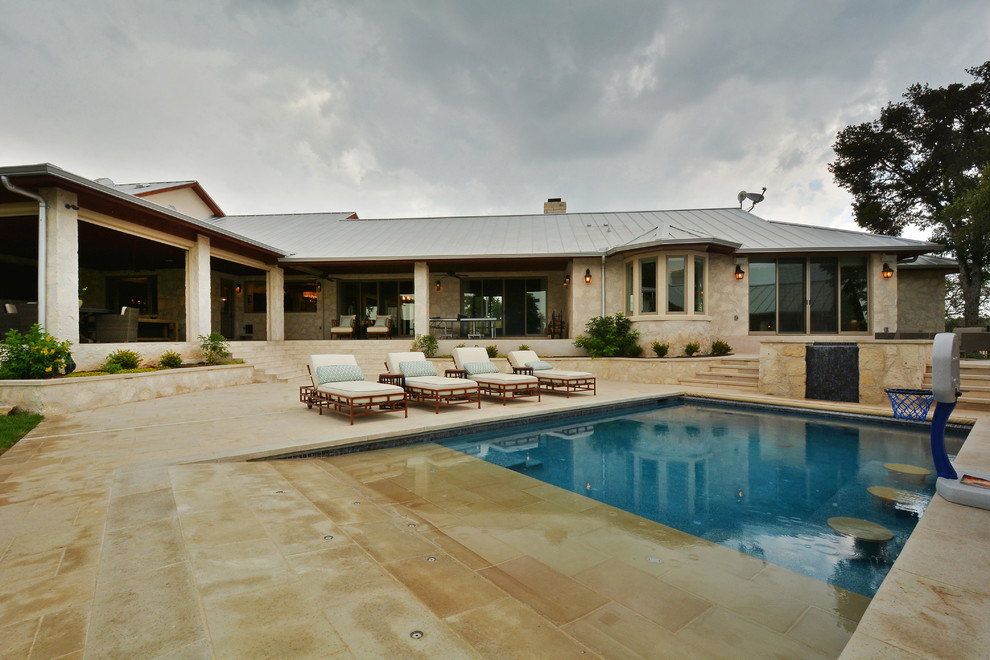 Ispirazione per un'ampia piscina monocorsia classica rettangolare dietro casa con fontane e cemento stampato