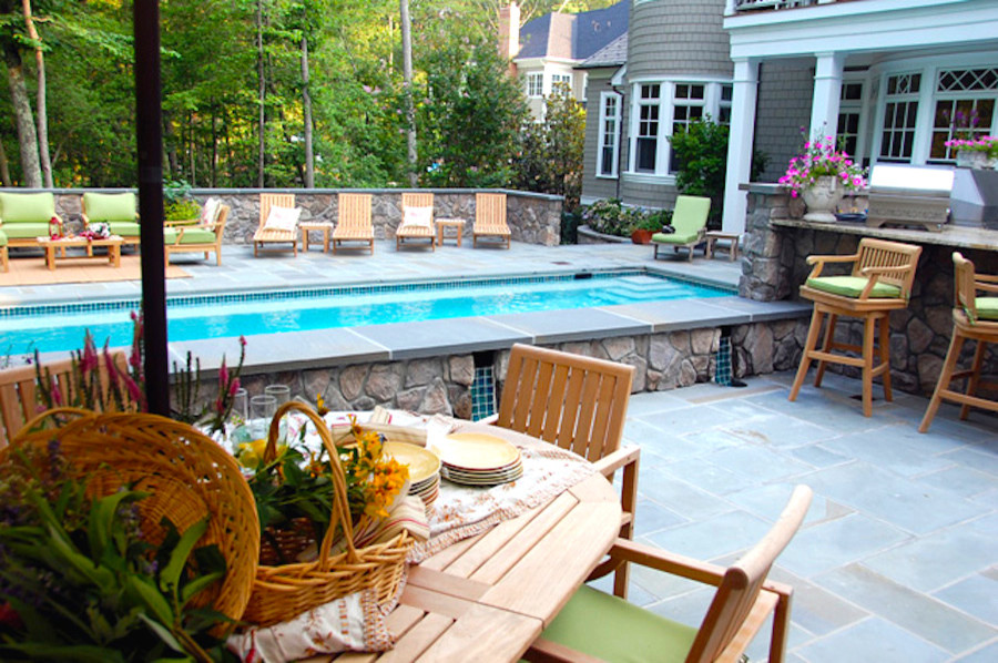 Modelo de piscina con fuente clásica grande rectangular en patio trasero con adoquines de piedra natural