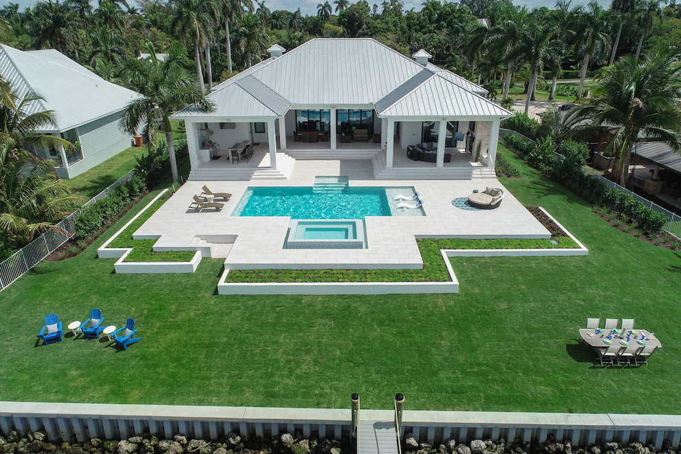 Modelo de piscinas y jacuzzis alargados contemporáneos grandes rectangulares en patio trasero con suelo de baldosas