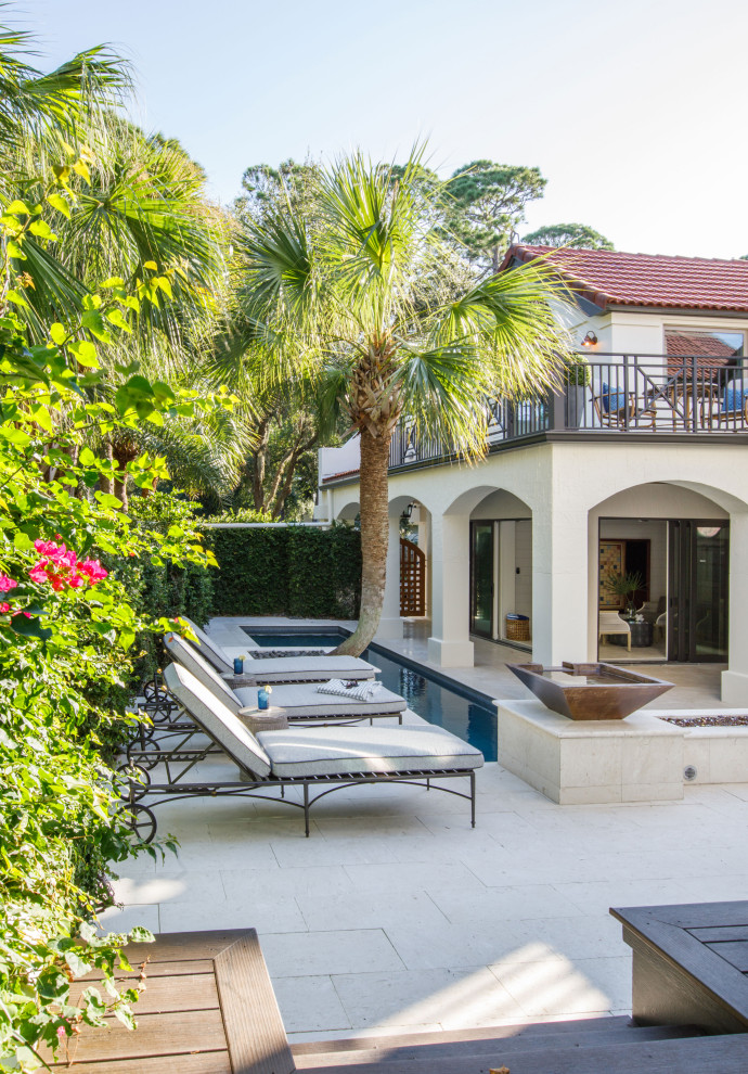 This is an example of an expansive mediterranean courtyard rectangular swimming pool in Jacksonville with with pool landscaping and natural stone paving.