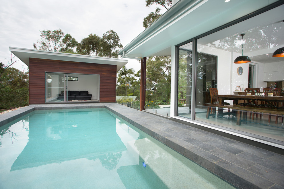 Réalisation d'un Abris de piscine et pool houses arrière design de taille moyenne et rectangle avec du carrelage.