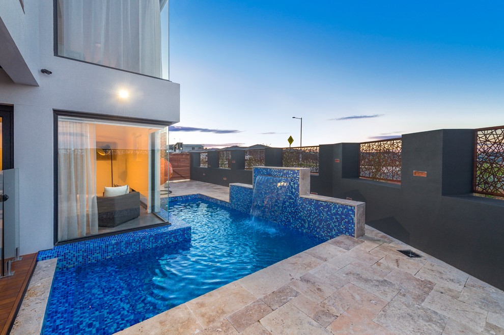 Inspiration for a large contemporary front l-shaped lengths swimming pool in Canberra - Queanbeyan with a water feature and natural stone paving.