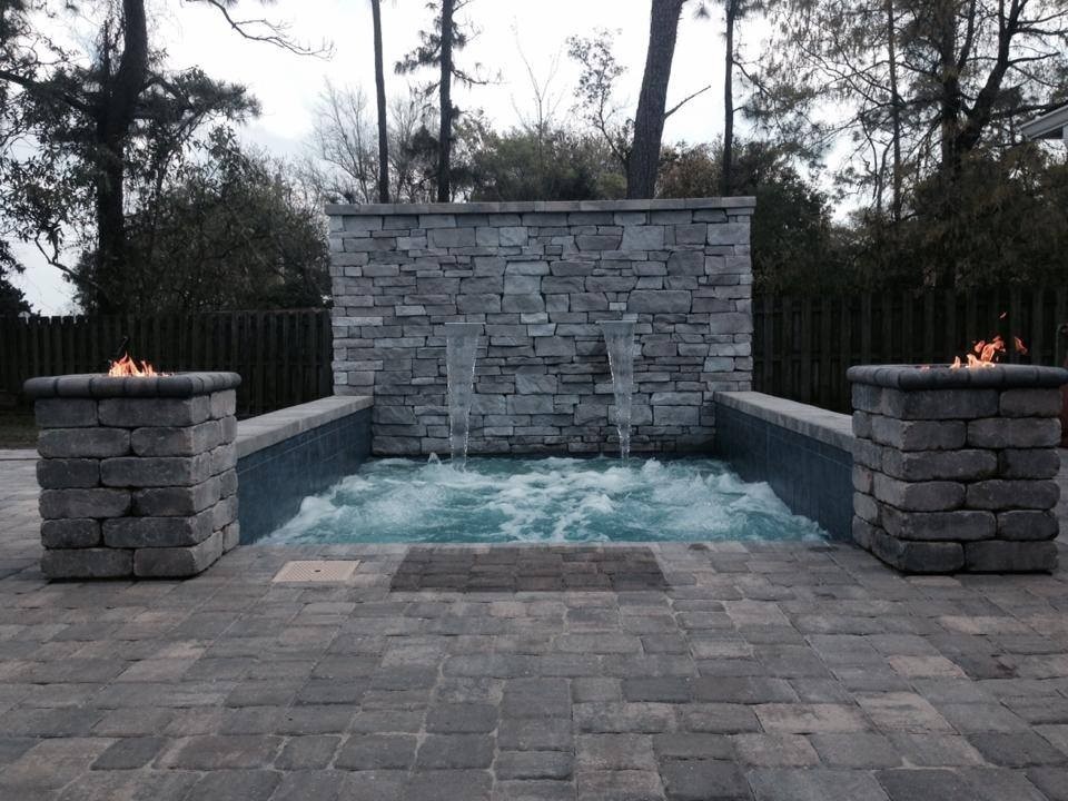 Cette image montre une petite piscine arrière chalet rectangle avec des pavés en brique et un bain bouillonnant.