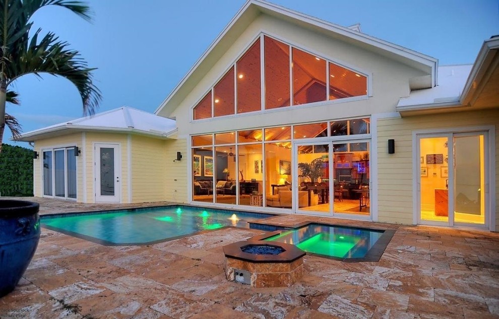 Mittelgroßer Pool hinter dem Haus in rechteckiger Form mit Natursteinplatten in Orlando