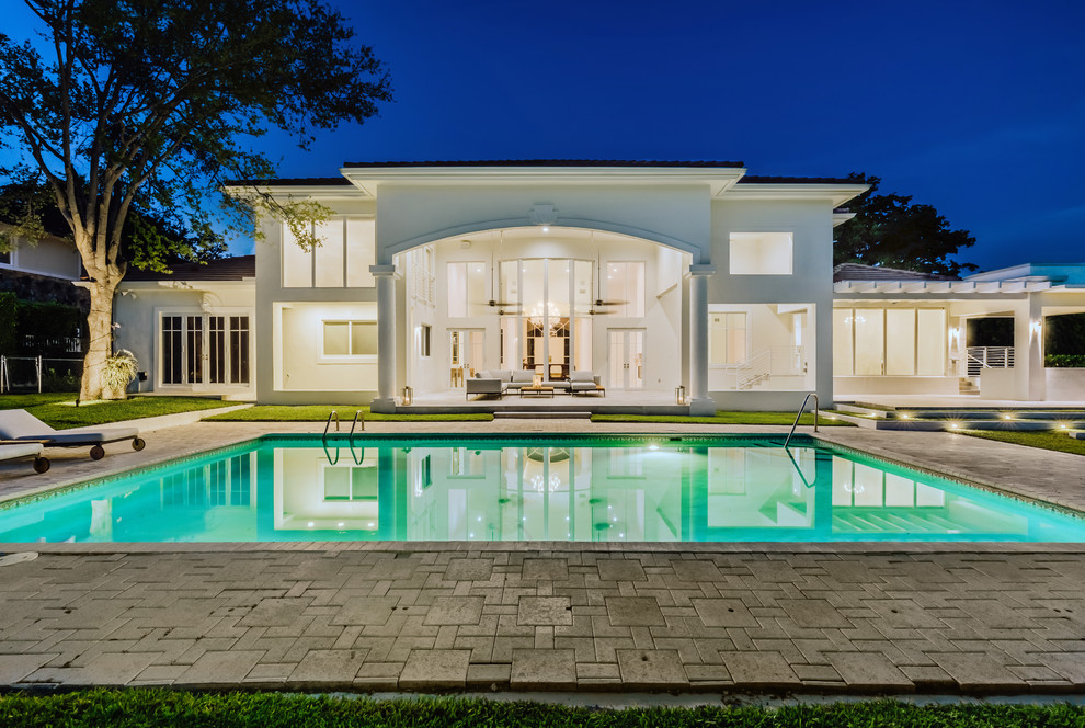 Inspiration for a contemporary back rectangular lengths swimming pool in Miami with brick paving.