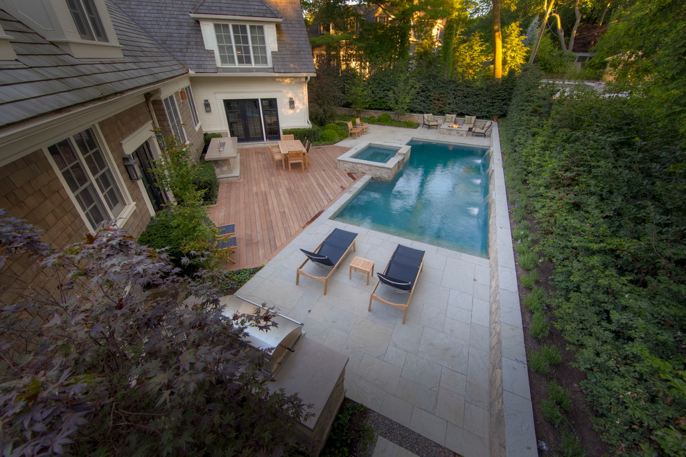 Réalisation d'une piscine arrière tradition de taille moyenne et rectangle avec un bain bouillonnant et une terrasse en bois.