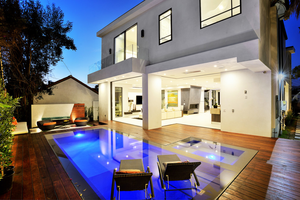 Ejemplo de piscinas y jacuzzis alargados contemporáneos grandes rectangulares en patio trasero con entablado