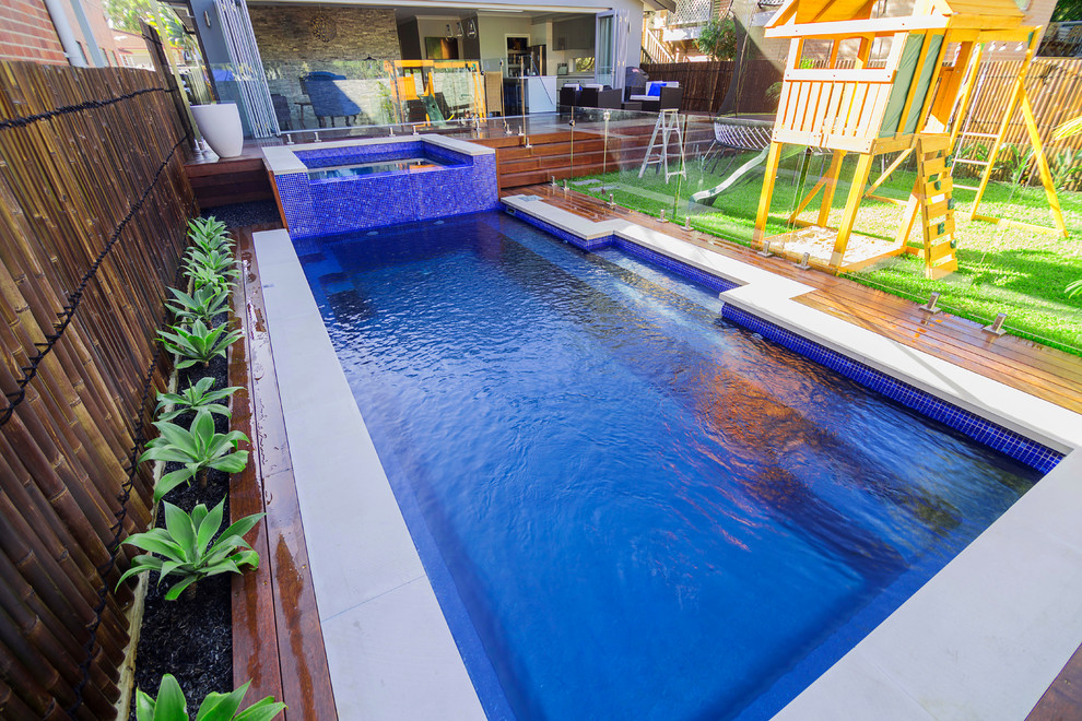 This is an example of a medium sized nautical back rectangular infinity hot tub in Sydney with decking.