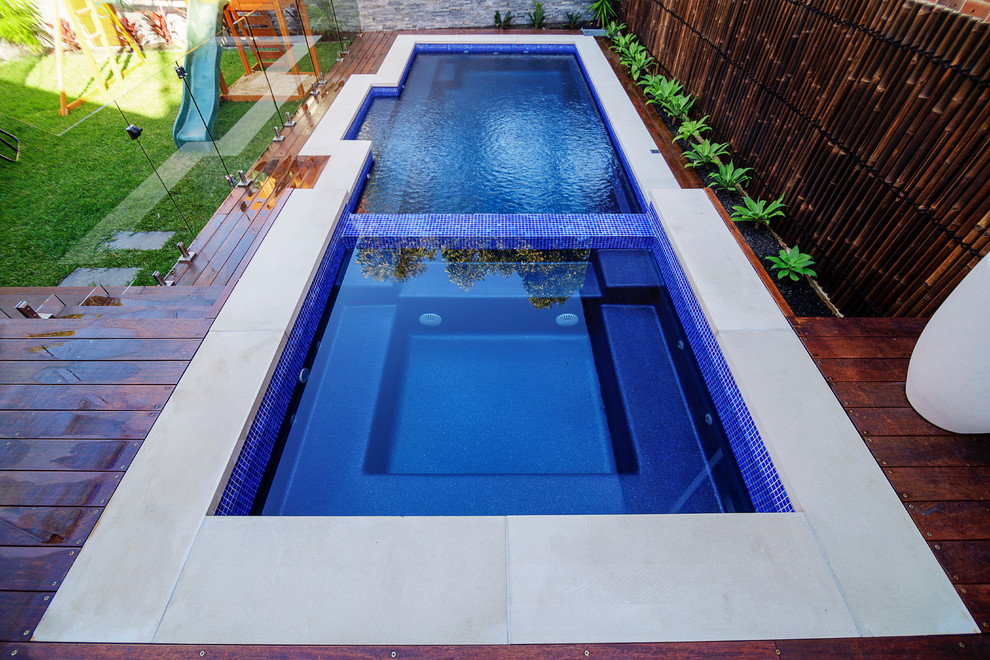 Inspiration for a mid-sized contemporary backyard rectangular hot tub remodel in Sydney with decking