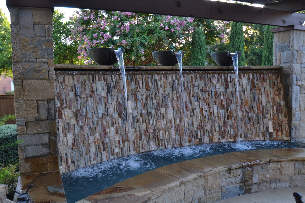 Пример оригинального дизайна: большой бассейн произвольной формы на заднем дворе в стиле неоклассика (современная классика) с покрытием из декоративного бетона и фонтаном