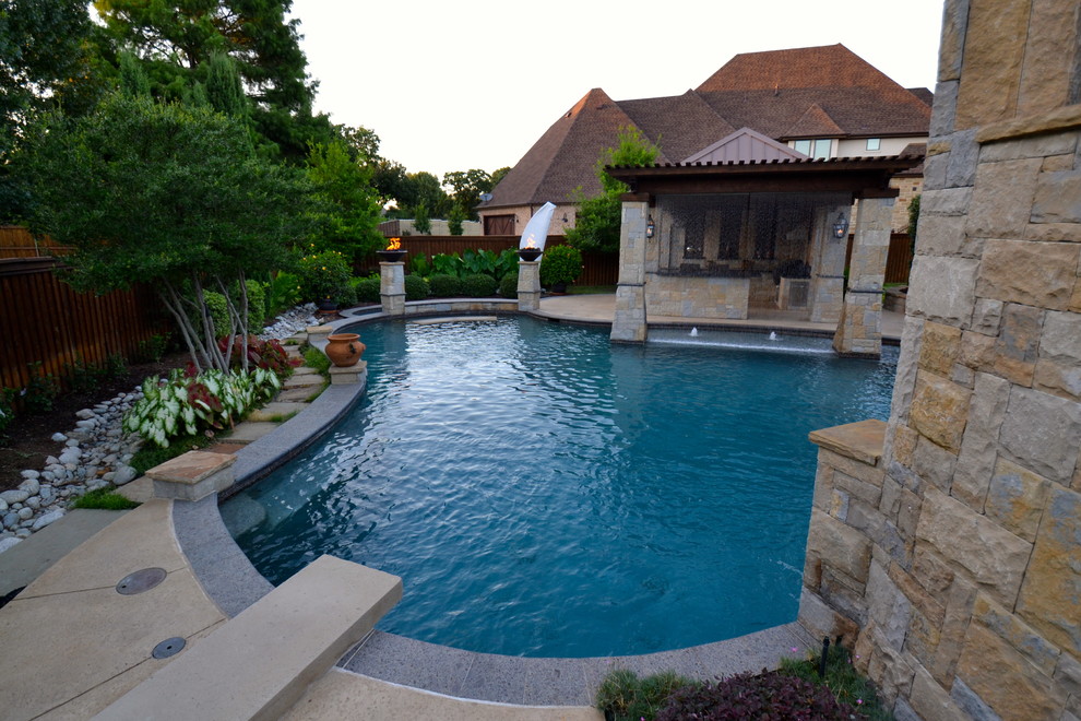 Modelo de piscina con fuente tradicional renovada grande a medida en patio trasero con suelo de hormigón estampado