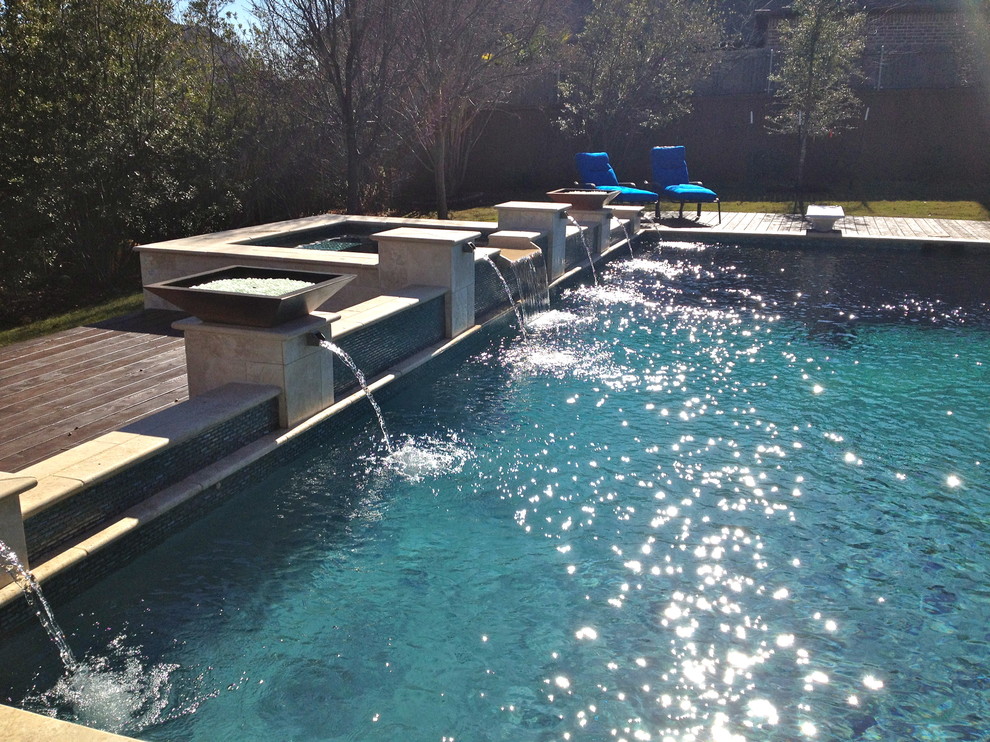 Esempio di una piscina monocorsia contemporanea rettangolare di medie dimensioni e dietro casa con una vasca idromassaggio e pedane