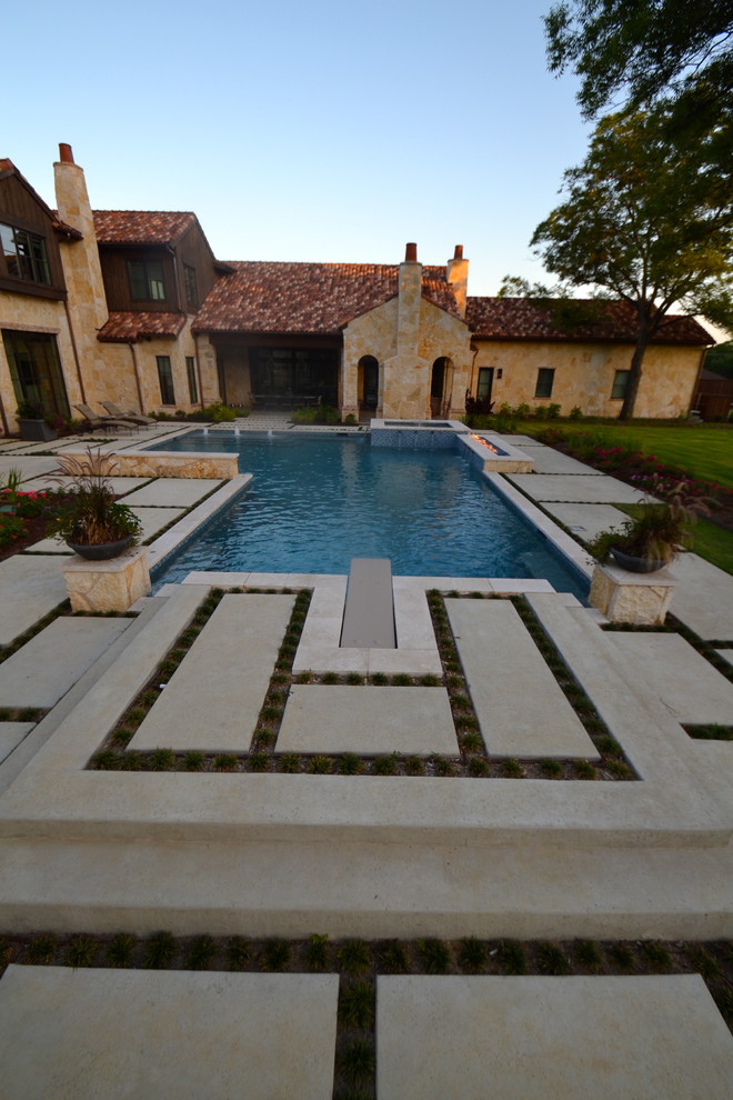 Modern inredning av en stor pool på baksidan av huset, med naturstensplattor
