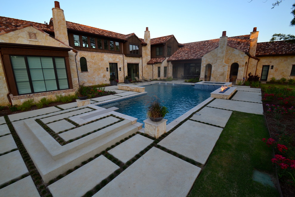 Diseño de piscina con fuente actual grande en patio trasero con adoquines de piedra natural