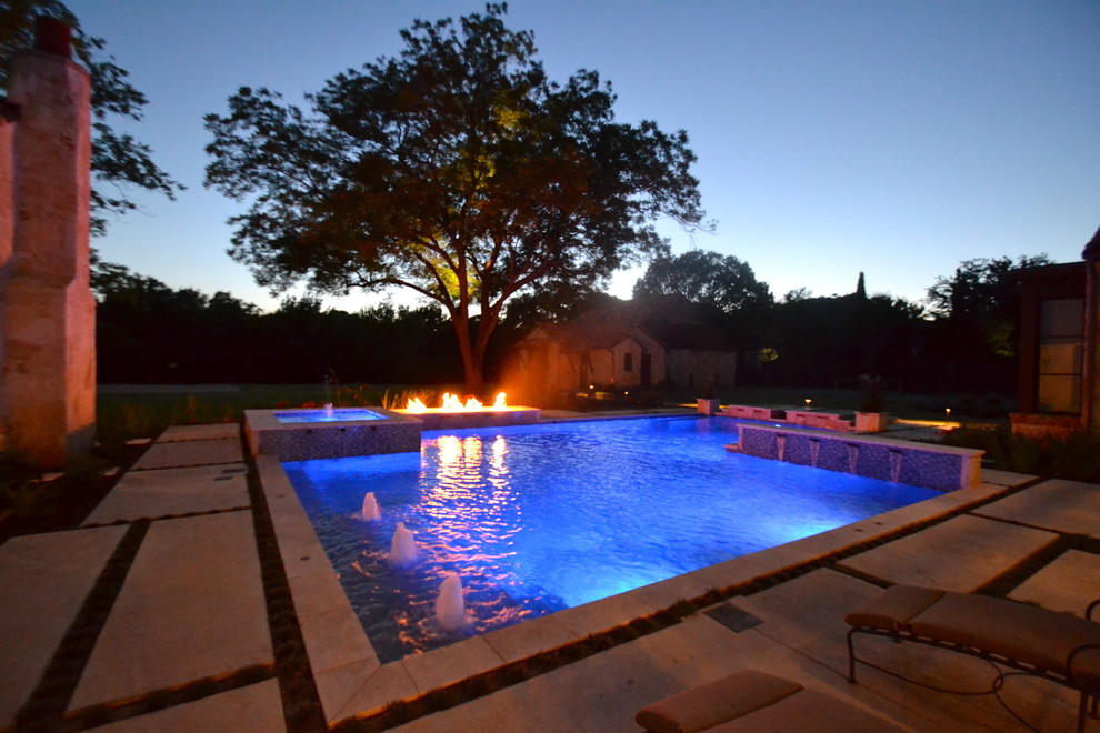 Immagine di una grande piscina contemporanea dietro casa con fontane e pavimentazioni in pietra naturale