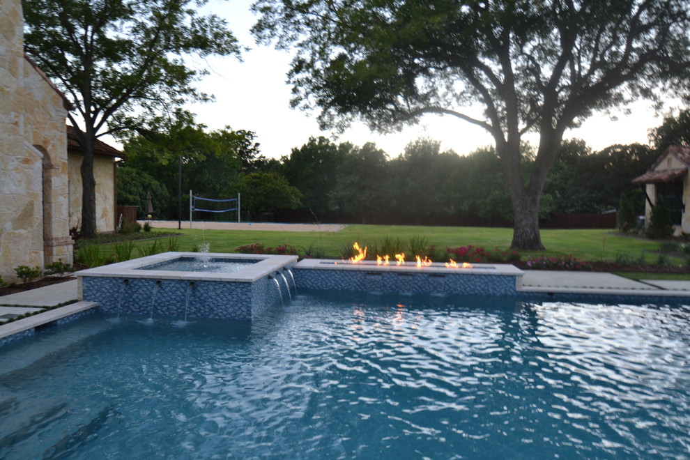 Modelo de piscina con fuente actual grande en patio trasero con adoquines de piedra natural