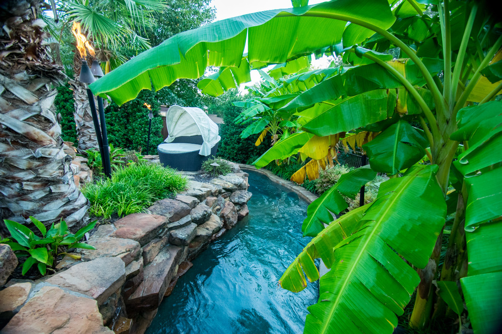 Idéer för en stor exotisk pool på baksidan av huset, med en fontän och naturstensplattor