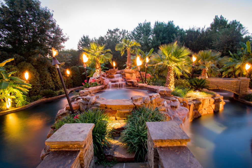 Example of a large island style backyard stone and custom-shaped pool fountain design in Dallas