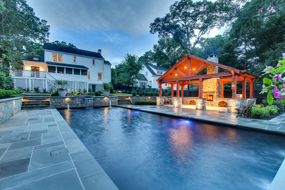 Imagen de piscina con fuente infinita contemporánea grande a medida en patio trasero con adoquines de piedra natural
