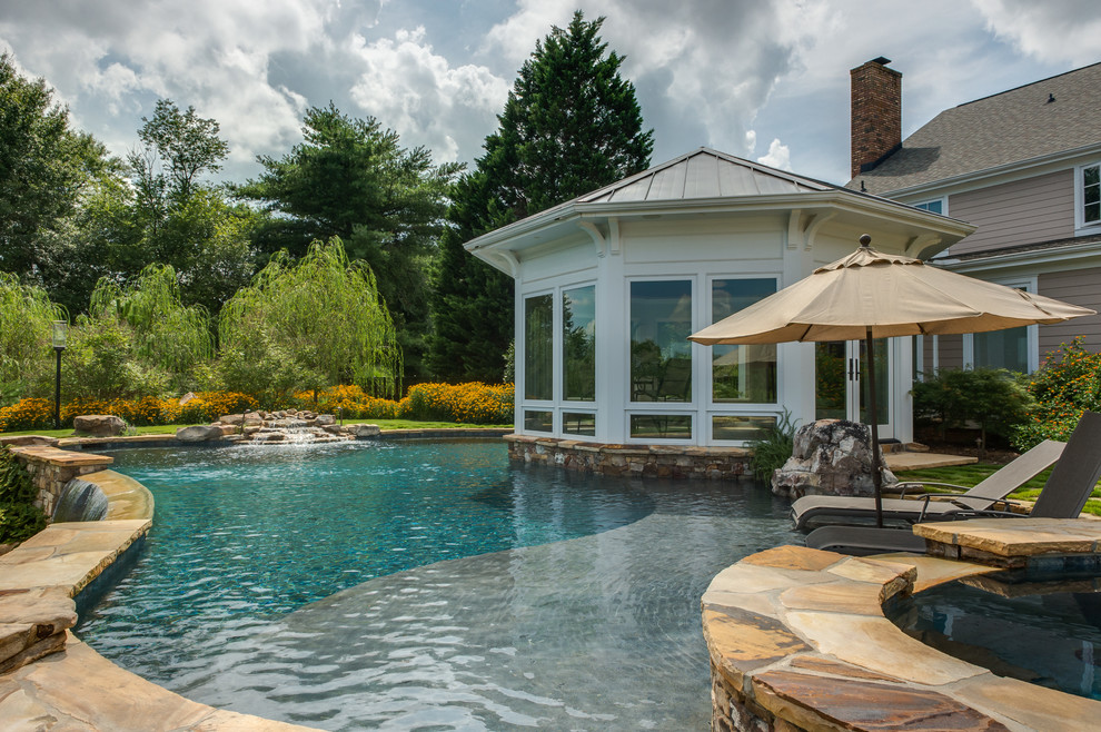 Foto di una piscina a sfioro infinito classica personalizzata di medie dimensioni e dietro casa con una vasca idromassaggio e pavimentazioni in pietra naturale