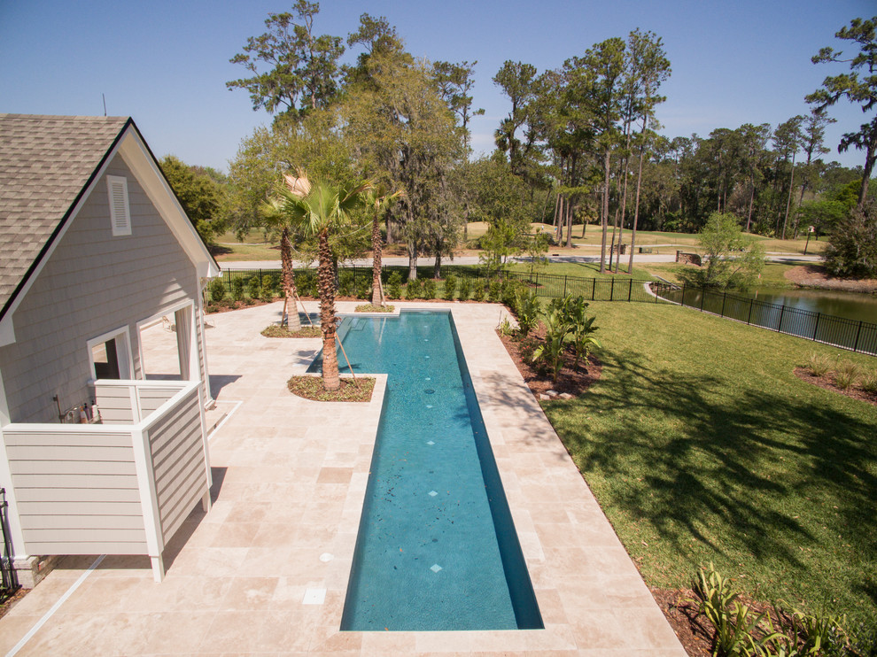 Diseño de piscina alargada marinera de tamaño medio rectangular en patio trasero con adoquines de hormigón