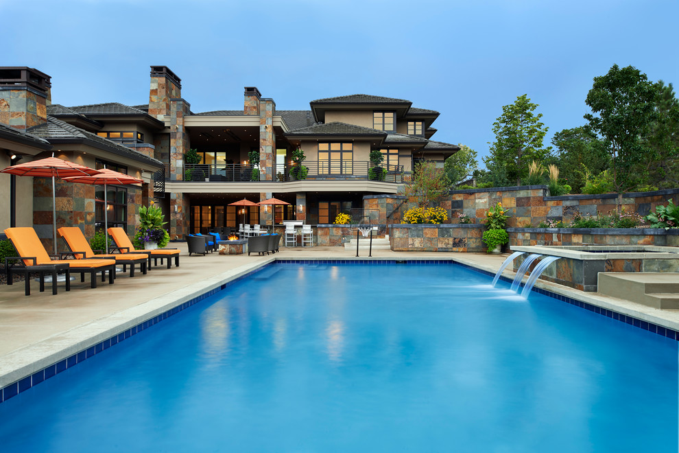 Immagine di una grande piscina design rettangolare dietro casa con fontane