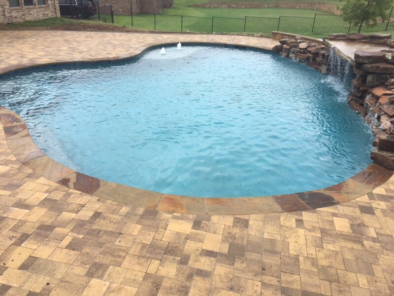 Foto de piscina natural de estilo americano grande a medida en patio trasero con adoquines de hormigón