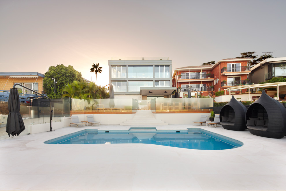 Idee per una grande piscina naturale minimal personalizzata dietro casa con pavimentazioni in pietra naturale